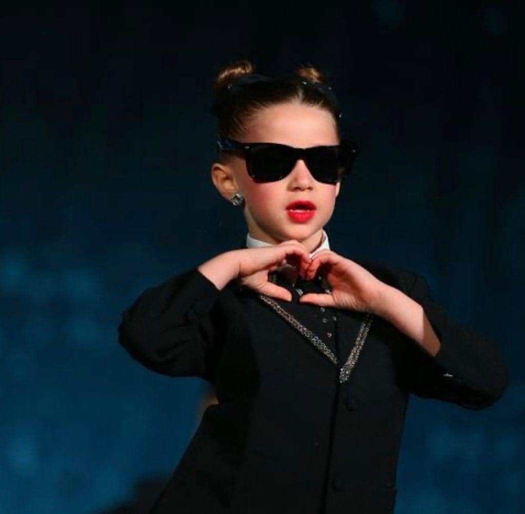 Young DPAC dancer making a heart shape on stage