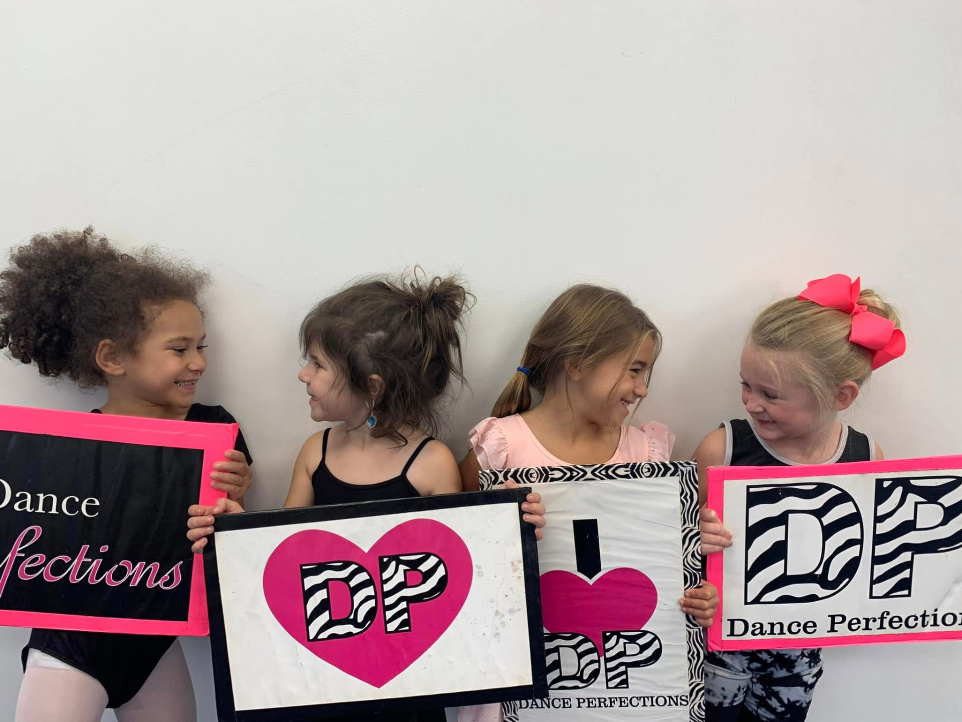 Dancers holding I Heart DP signs in the studio