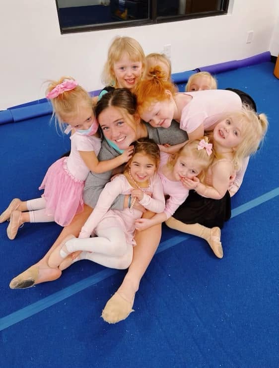Preschool dancers piled around their teacher for a giggly group photo