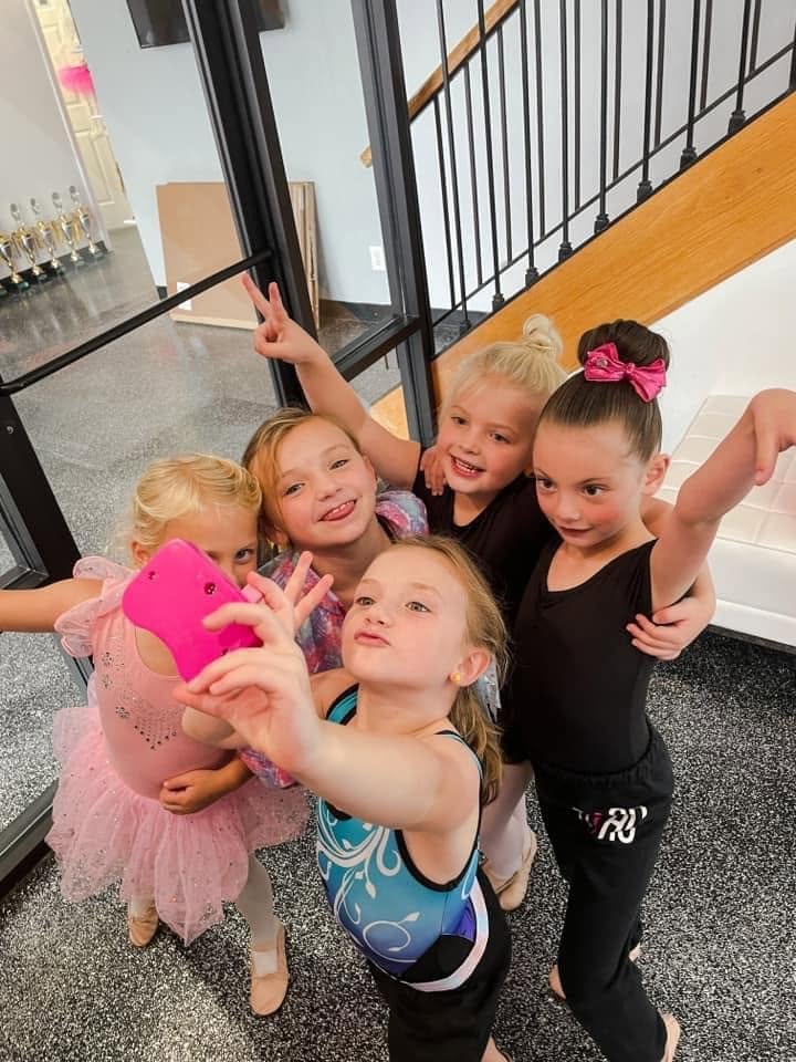 Five young dancers taking a silly selfie in the studio lobby