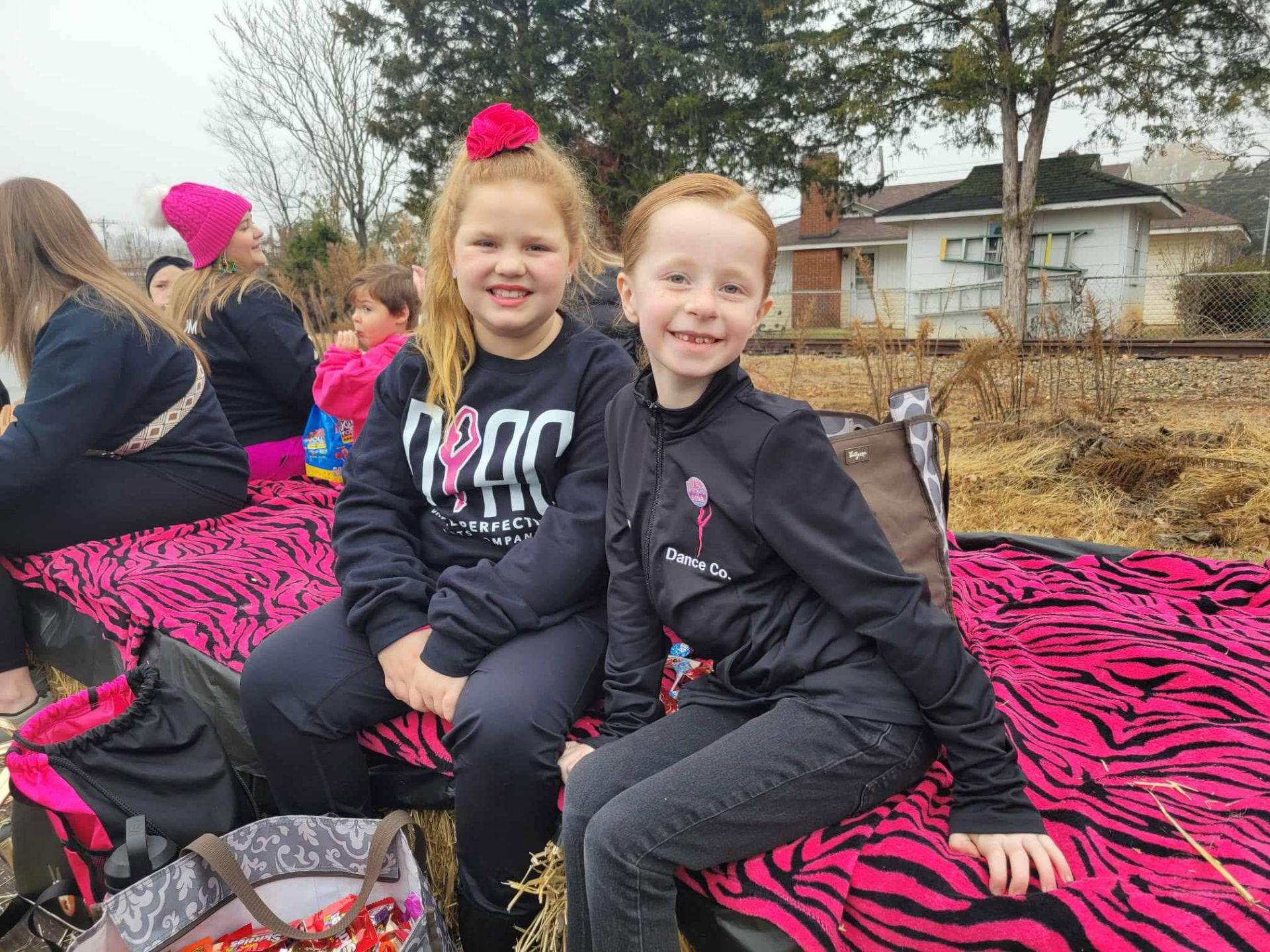 Two young Dance Perfections dancers riding the parade float together