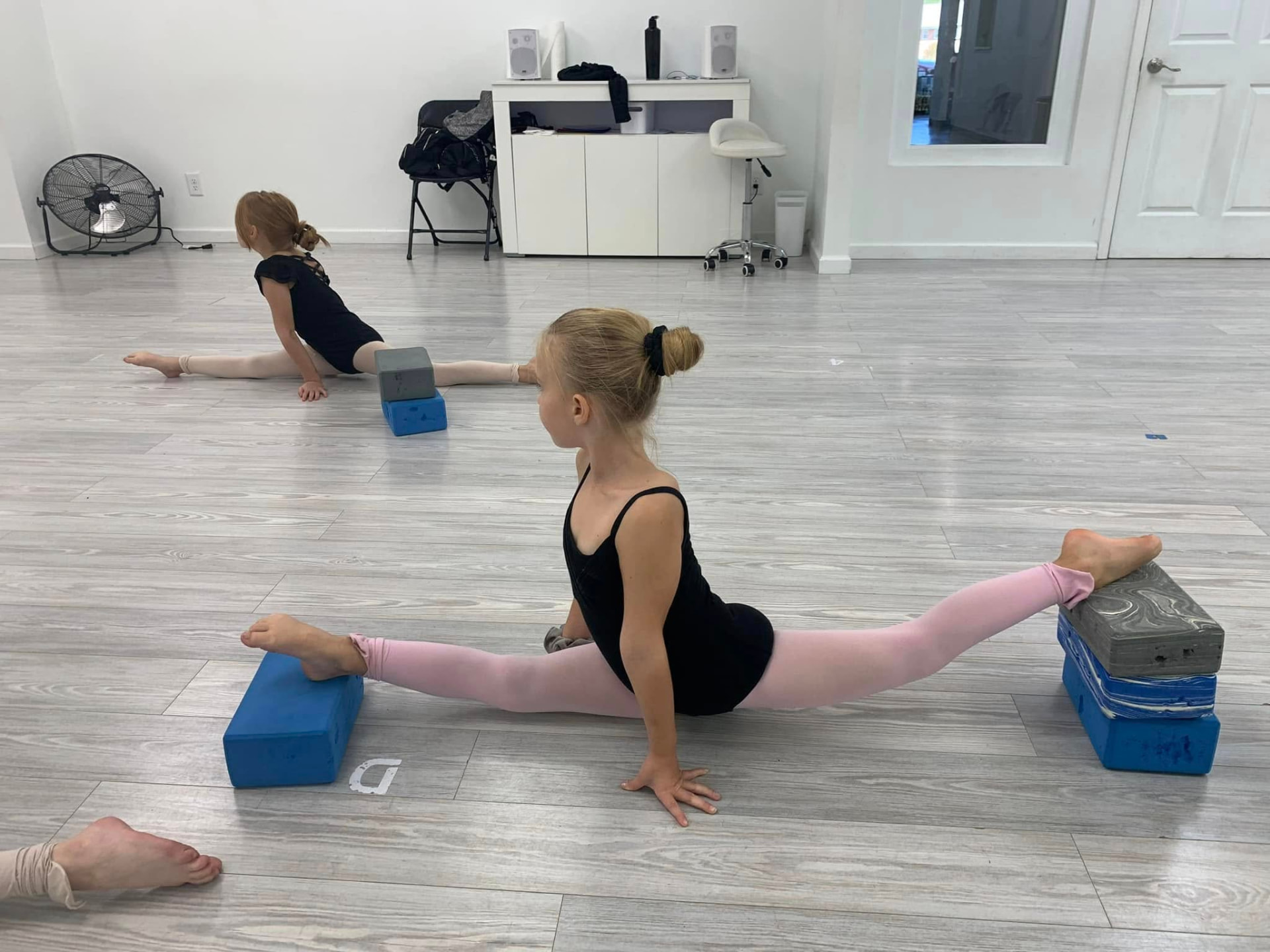 Young dancers stretching their splits over foam blocks in the studio